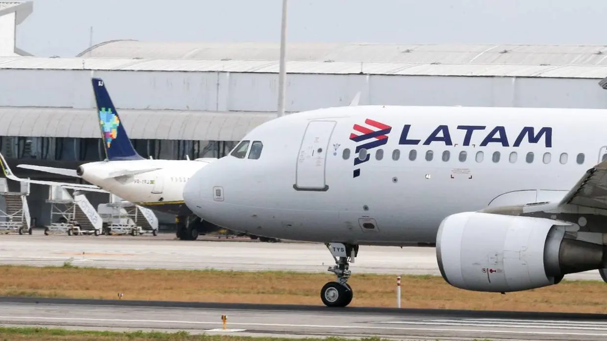 Imagem de uma aeronave da Latam no pátio do aeroporto.