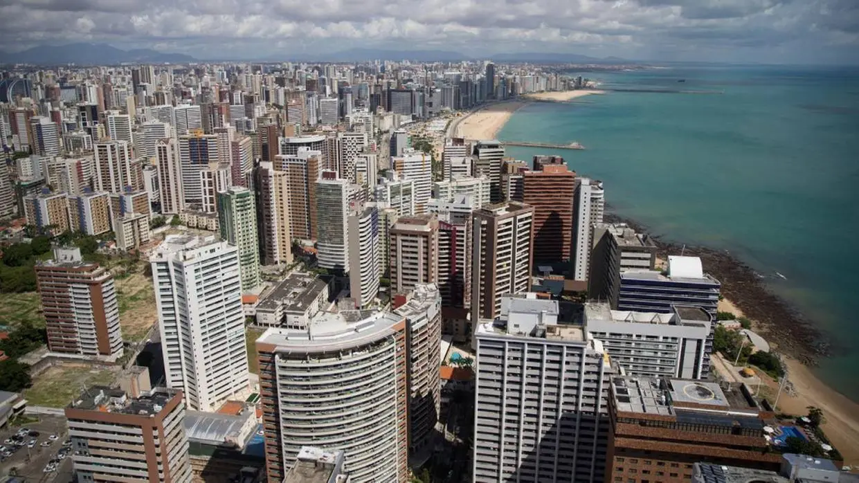 Foto mostra vista área da cidade de Fortaleza, com altos prédios e trecho da orla da praia