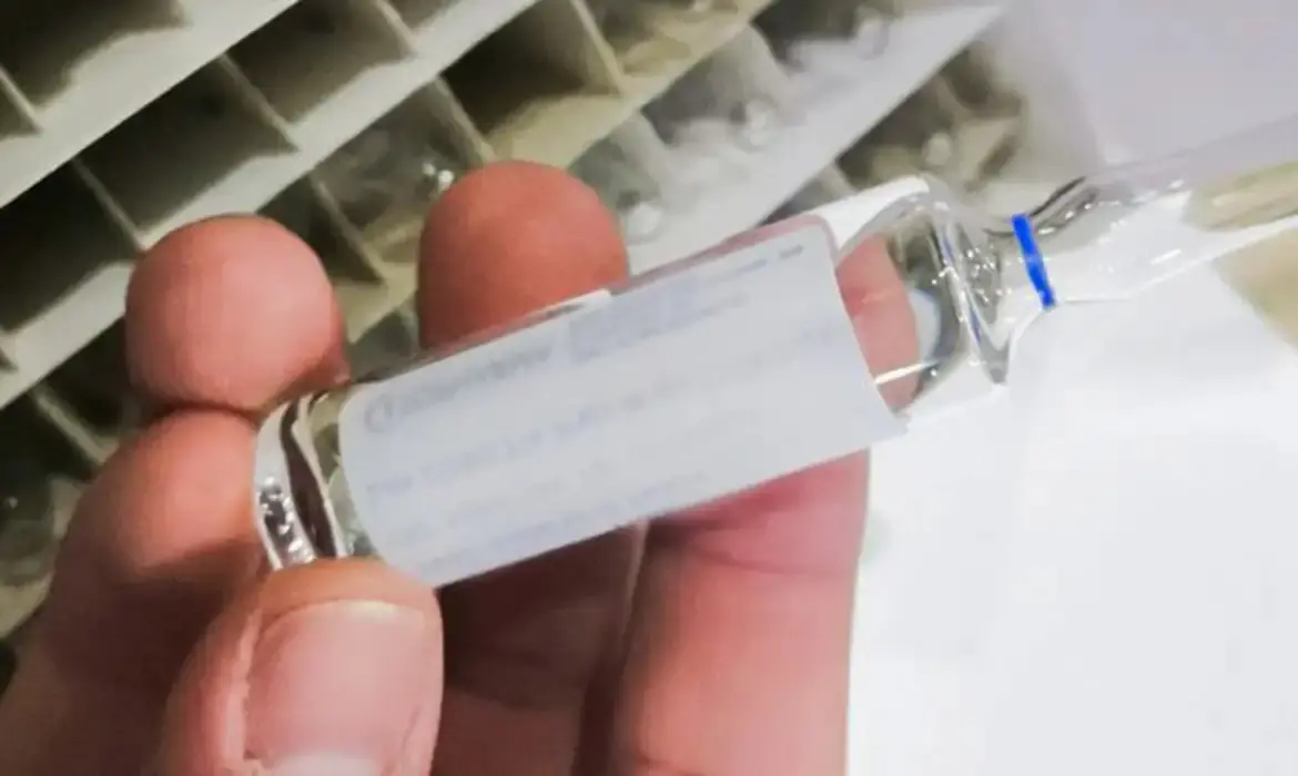 Mão segura frasco de etanol farmacêutico.