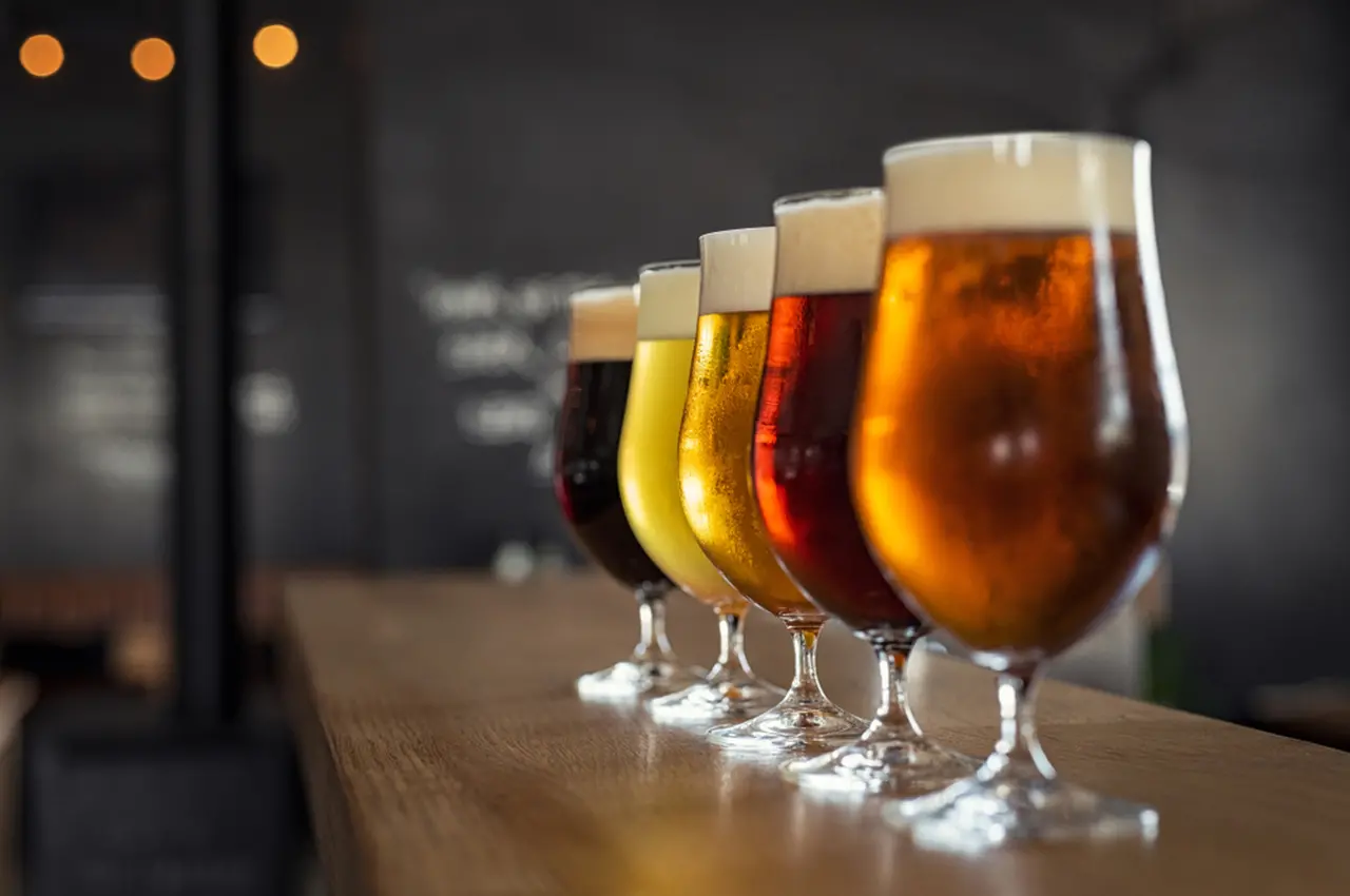 Cerveja colocadas em cima do balcão de madeira de um bar