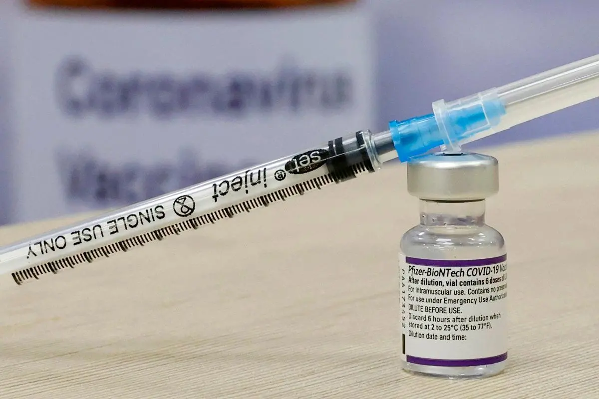 Imagem mostra vacina da Pfizer contra COVID-19 preparada com uma seringa, representando a aplicação de vacinas para imunização contra a COVID-19.