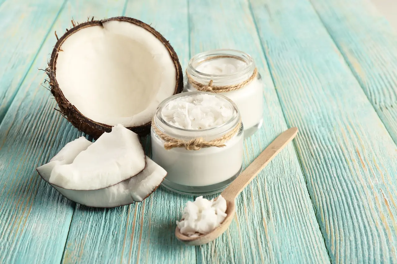 Óleo de coco sólido próximo a cocos abertos