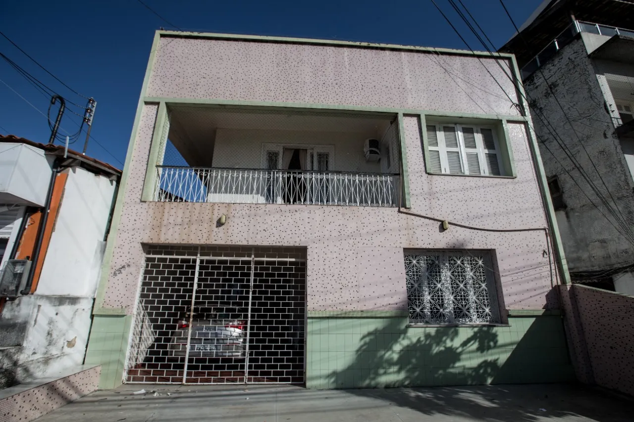 A casa de fachada de cerâmica rosa e verde é duplex e fica de frente para o mar