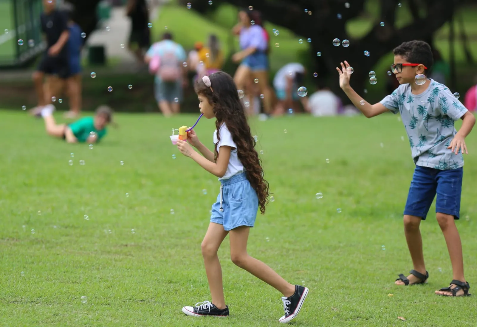 Crianças brincam com bolhas de sabão no Parque do Cocó