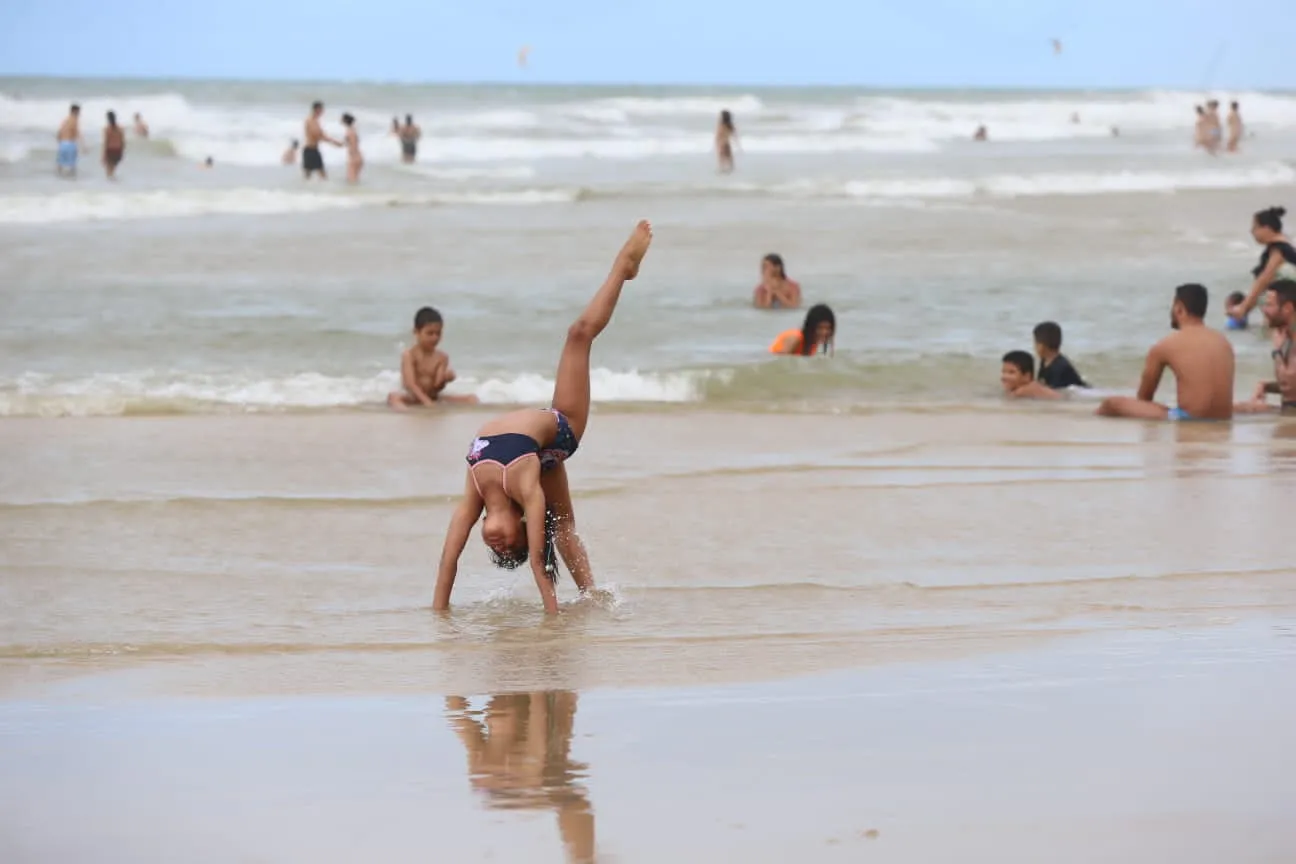 Criança, jovens e adultos aproveitam a praia neste domingo