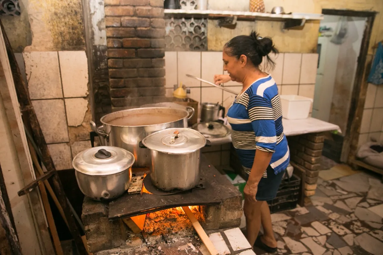 Uma das filhas de seu Paraíba, é Simone quem cozinha o famoso feijão servido na casa, preparado no fogão à lenha