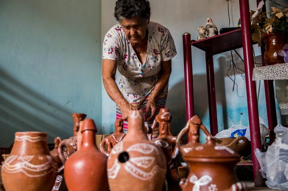 Maria Quirino da Silva, mais conhecida como Dona Tarina, é de Cascavel e  trabalha o barro utilizando técnicas ancestrais em um processo completamente artesanal
