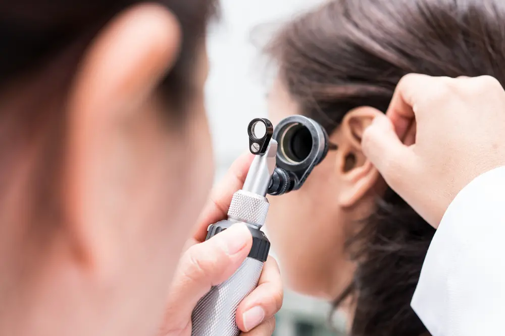 Médico examina ouvido de paciente