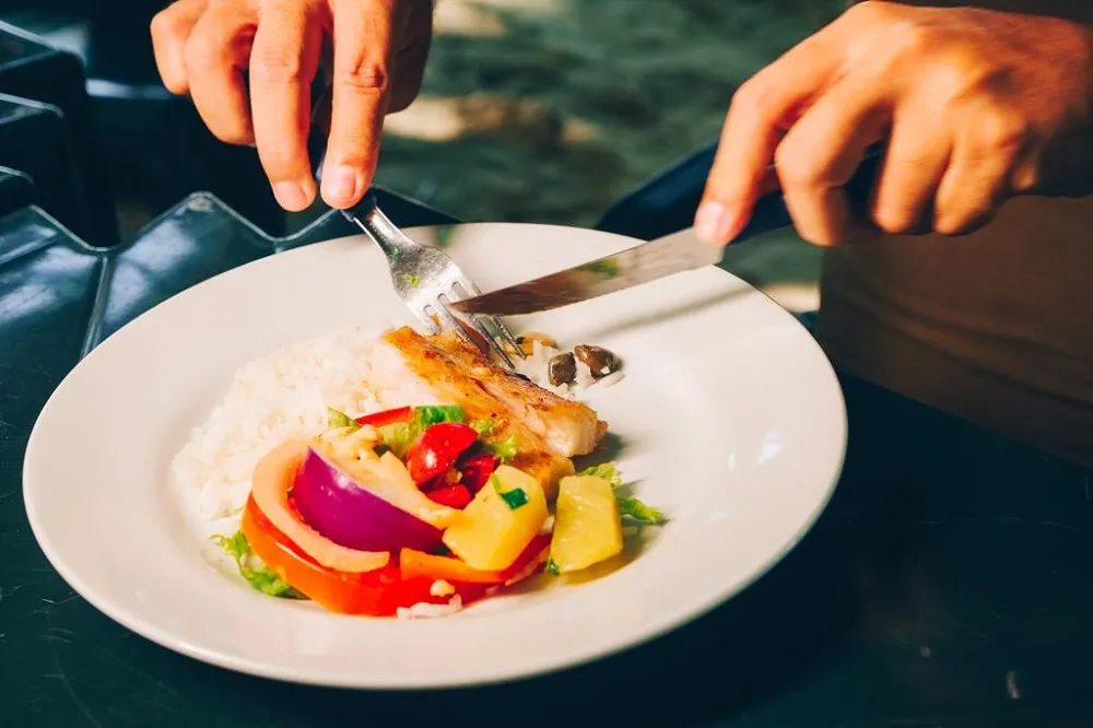 O Peixe à Belle Meuniére é feito com filé de pescado grelhado e acompanha molho de alcaparras com pimentão, tomate-cereja e azeite