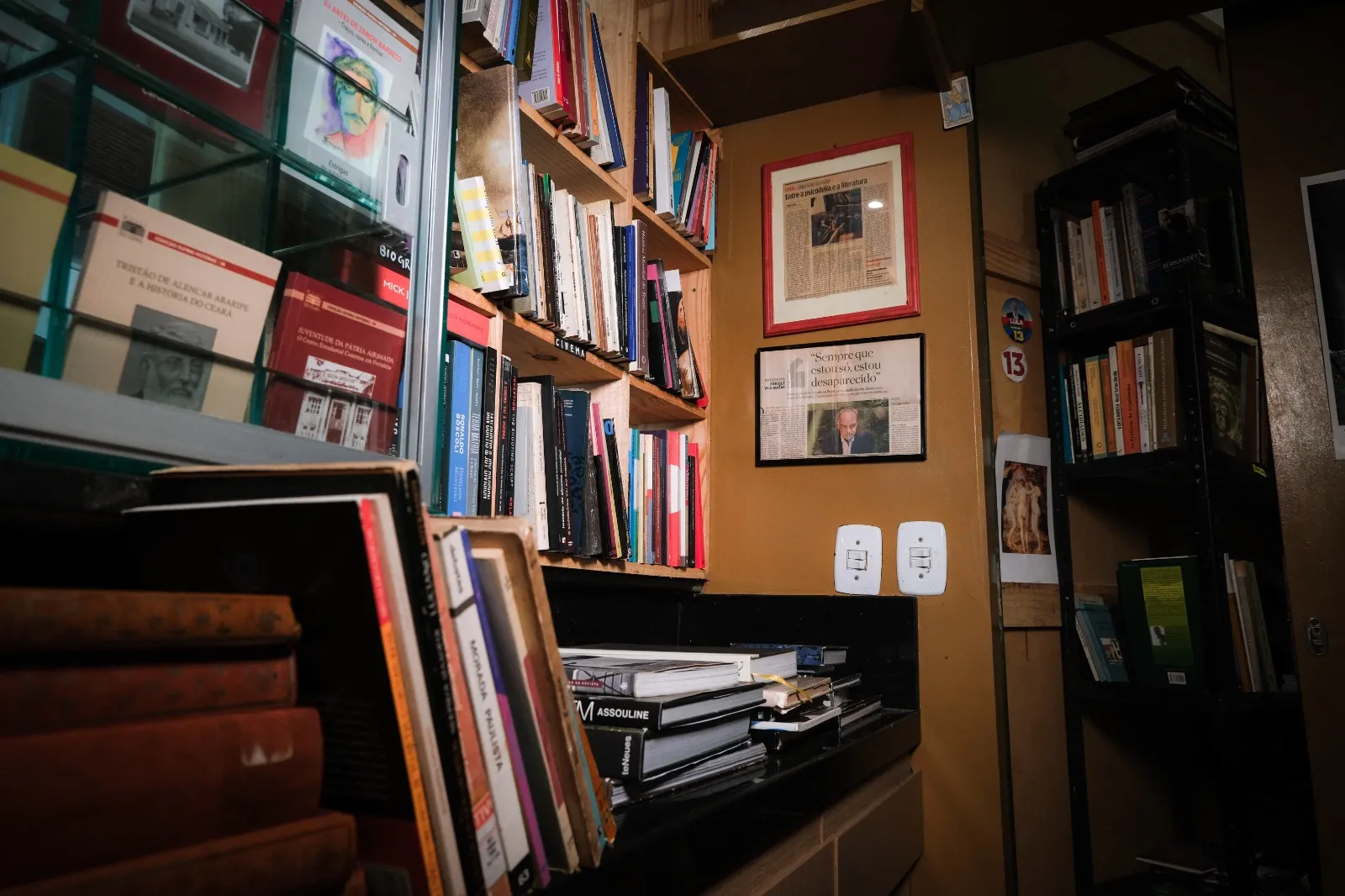 Recortes de jornal, placas, discos de vinil, prints, ímãs e velas aromáticas dividem espaço com obras em brochura
