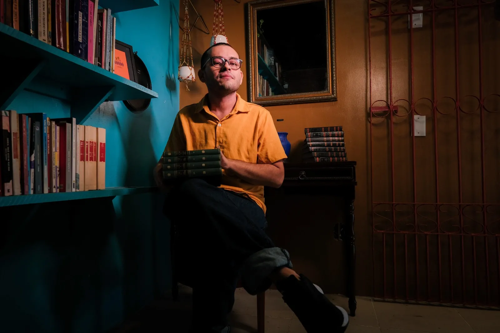 Um dos espaços mais bonitos do sebo tem um espelho e livros clássicos ao redor