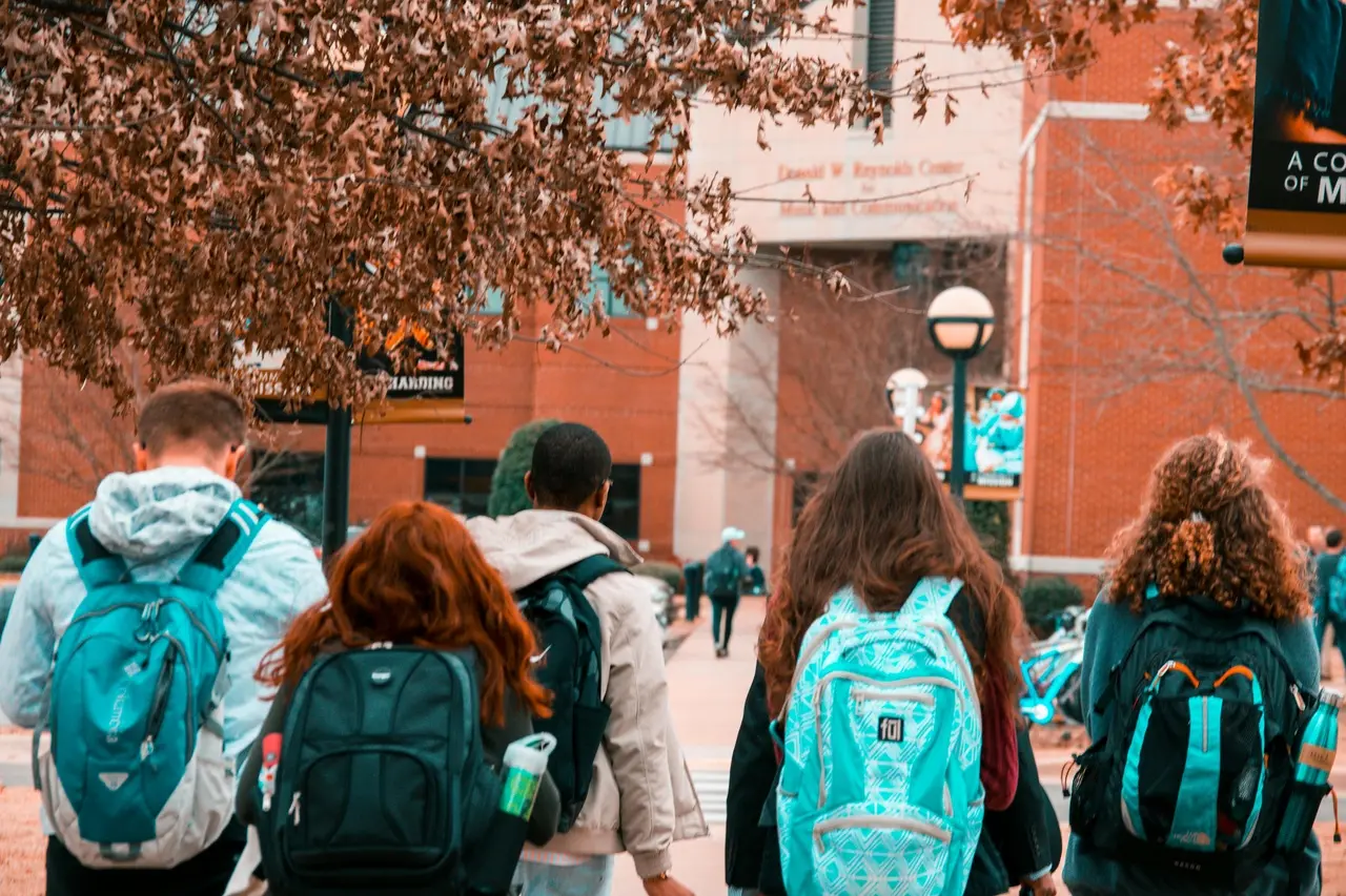 Imagem de estudantes de costas com suas mochilas
