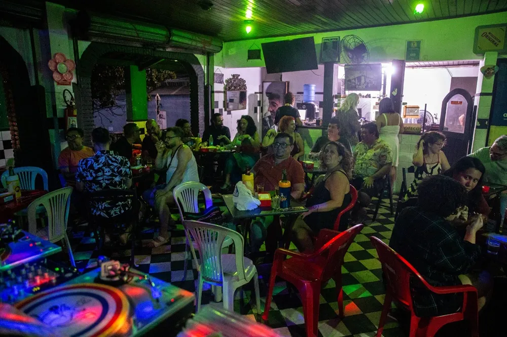De cima para baixo: Angela Sena, proprietária do boteco; suíno com fritas, um dos carros-chefes da casa; e o movimento do bar em dias de brega