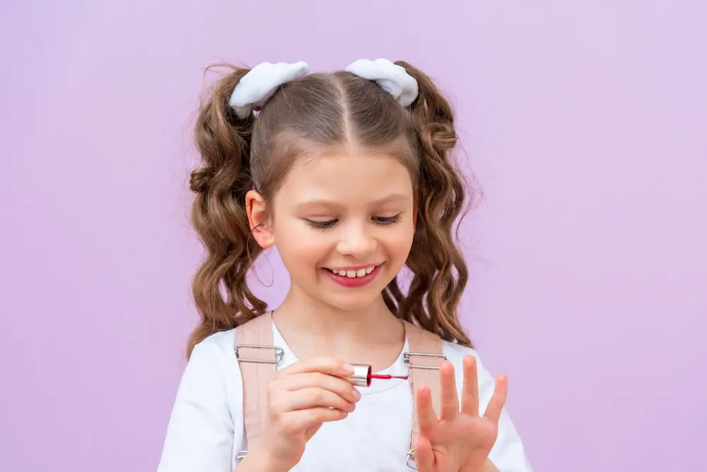 foto de criança aplicando esmalte em unha.