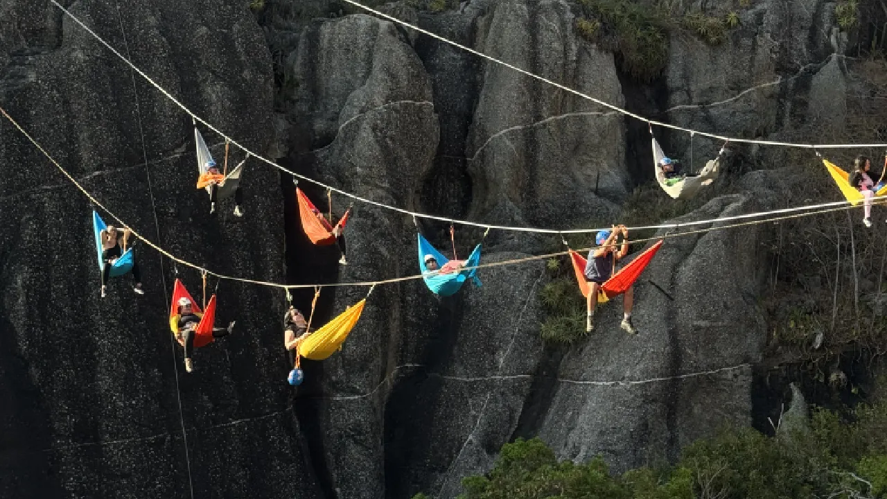 Grupo de pessoas deitadas em redes no alto da Ponte da Barra