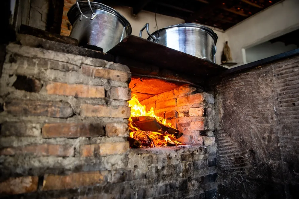 Fogão à lenha está no Iran da Panelada desde o começo do negócio, e garante comida quentinha sempre