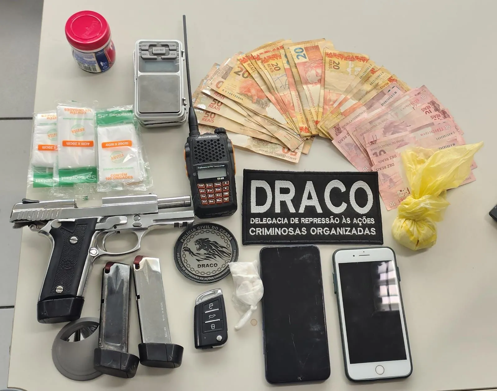 Uma arma de fogo, carregadores, drogas, dinheiro, celulares e um radiocomunicador foram apreendidos com suspeitos de integrar a facção Comando Vermelho.