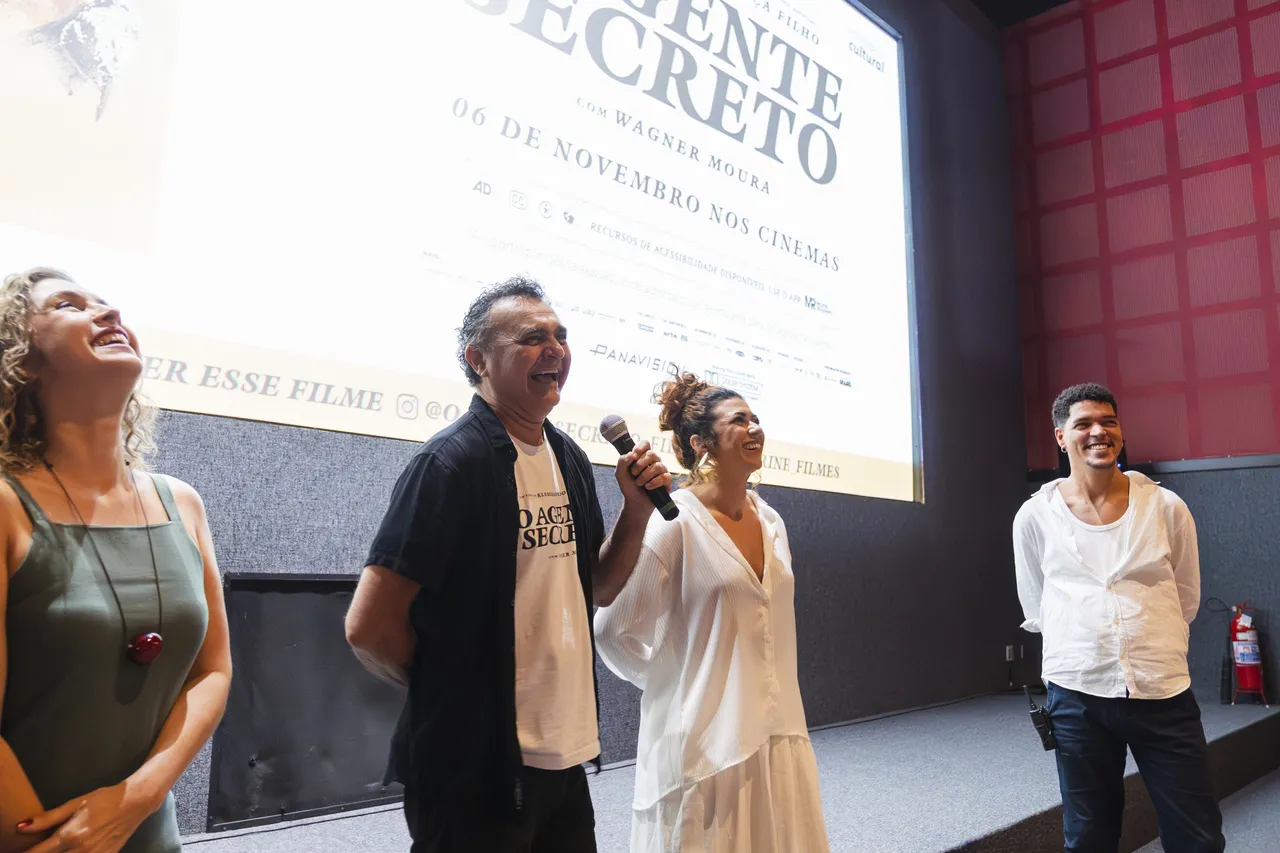 Robério Diógenes (ao centro, à esquerda, segurando microfone) e Geane Albuquerque (ao centro, à direita, de vestido branco) em pré-estreia de 