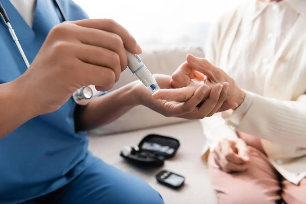 Pessoa recebendo auxílio de enfermeira para medição de diabetes. Imagem em matéria sobre o suplemento insupril, proibido pela Anvisa.